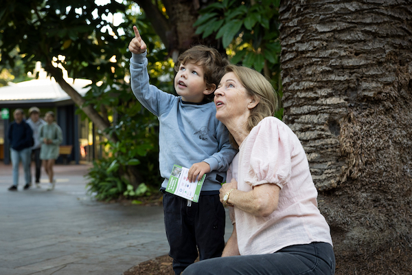 Grandmother and child point at animals