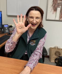 Woman with smiley face drawn on hand