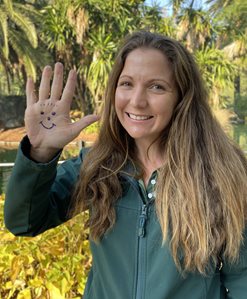 Woman with smiley face drawn on hand